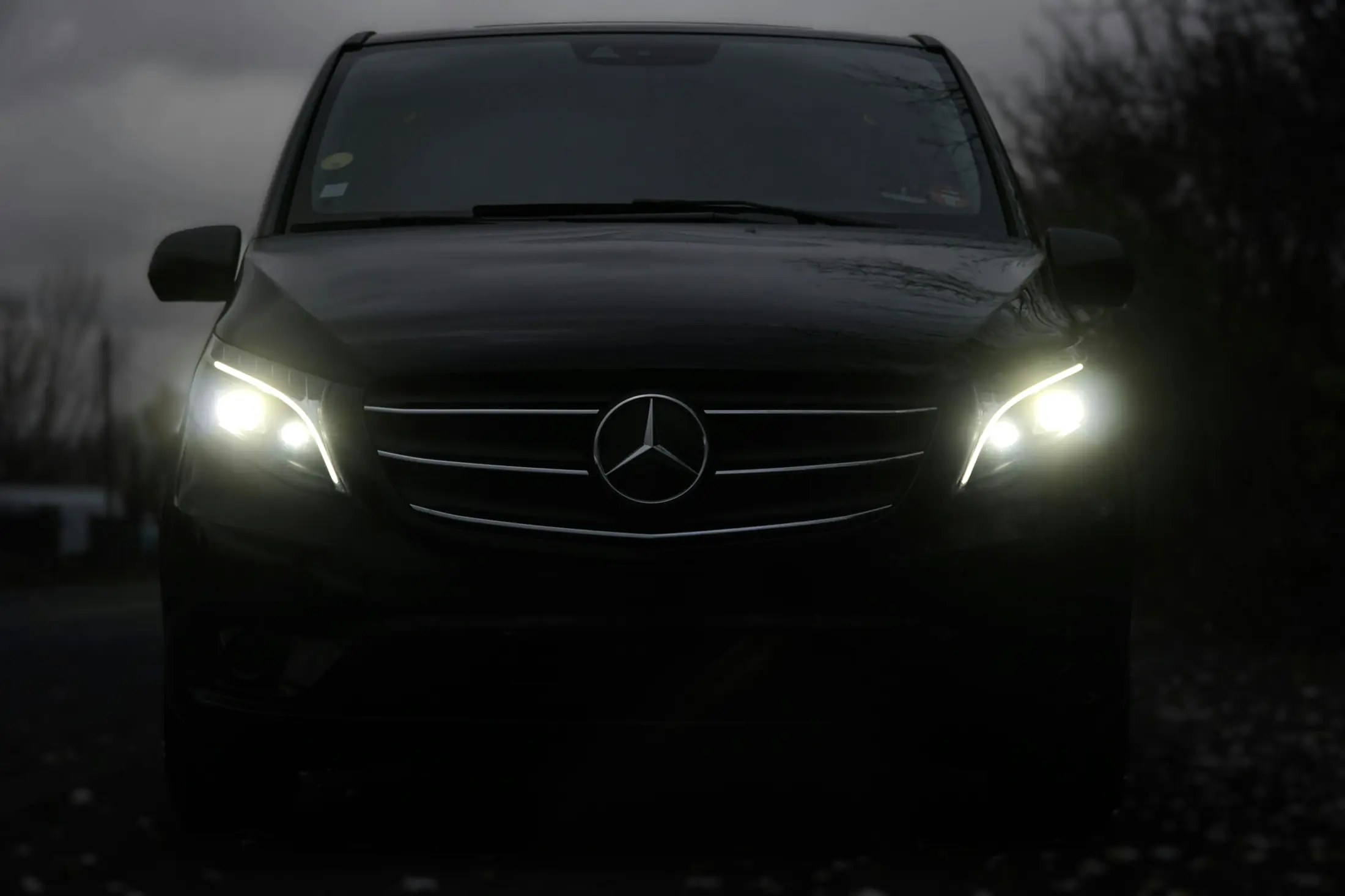 Black Mercedes-Benz Vito with its headlights on at night